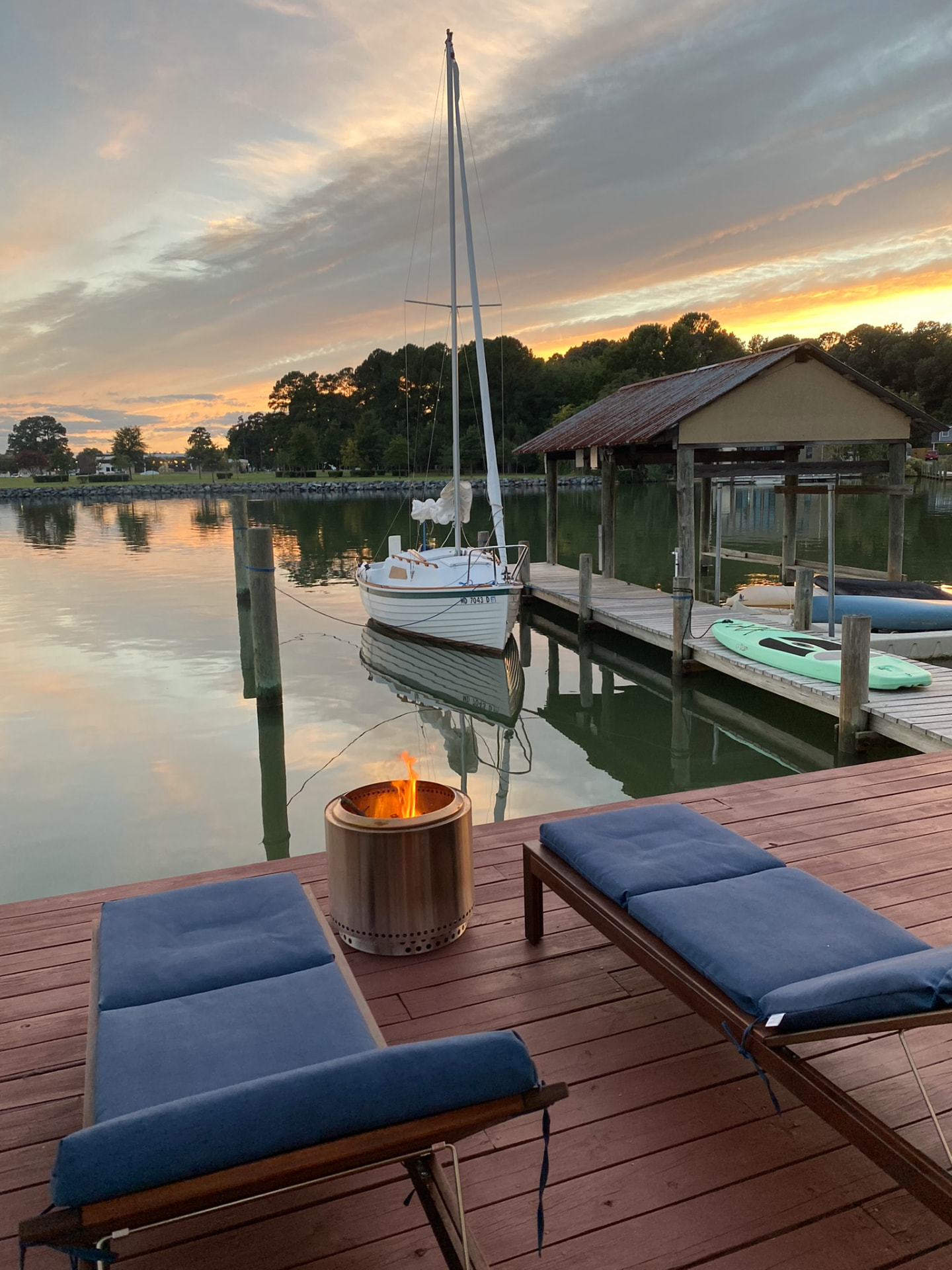 Spoonful moored beside the dock at sunset with a fire pit burning