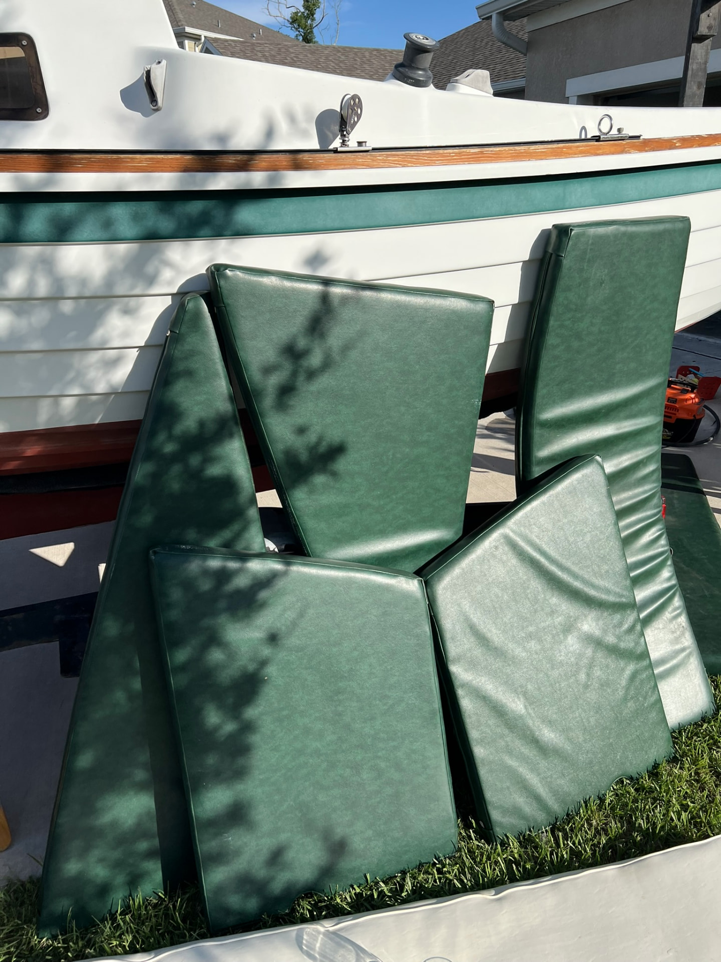 Green vinyl interior cushions set out beside the hull